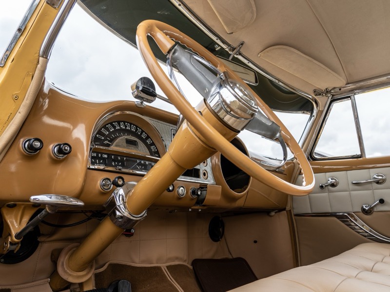 Armaturenbrett eines Oldtimers mit Chromlenkrad und Rundtacho